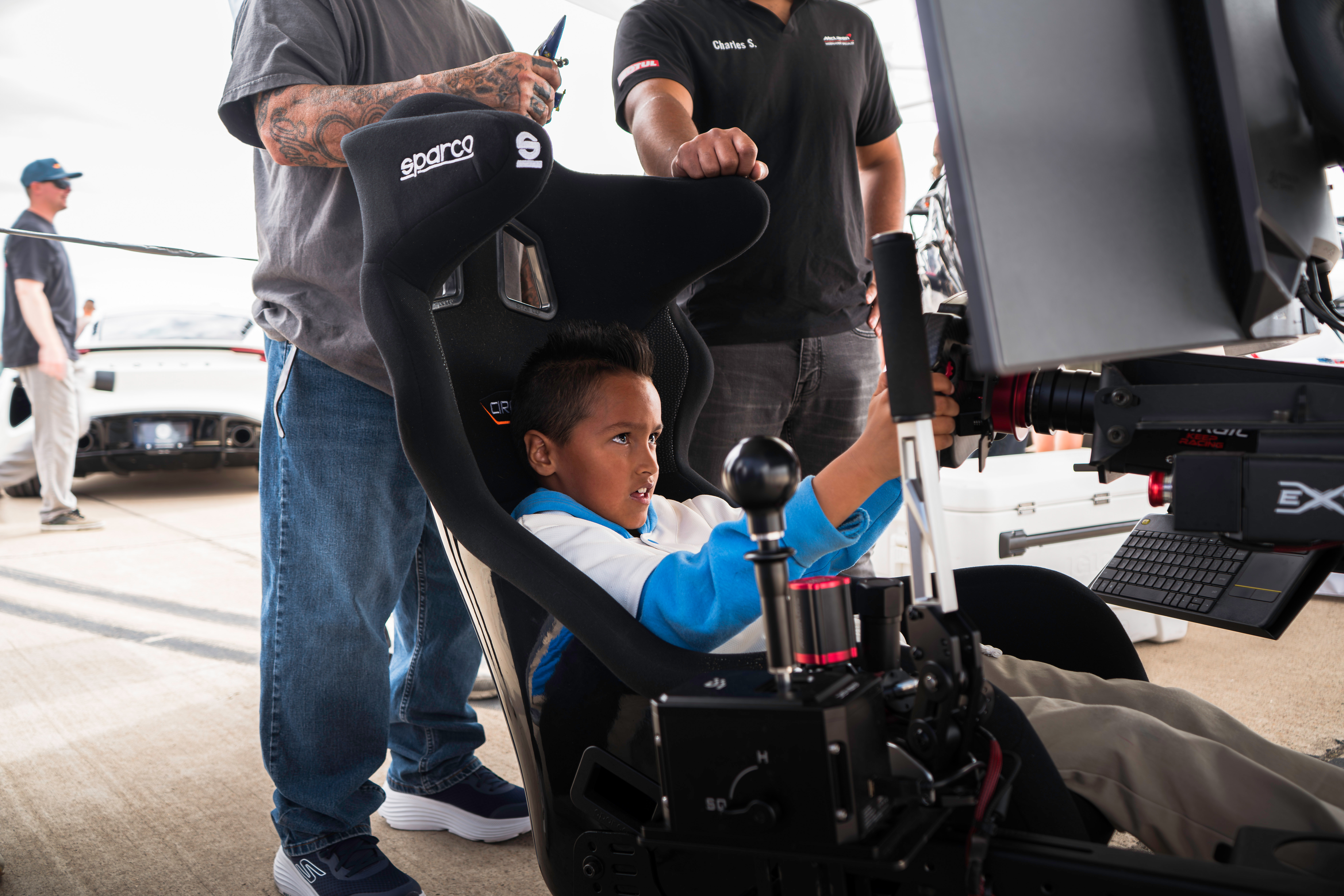 Young racer in the sim rig with crowd watching