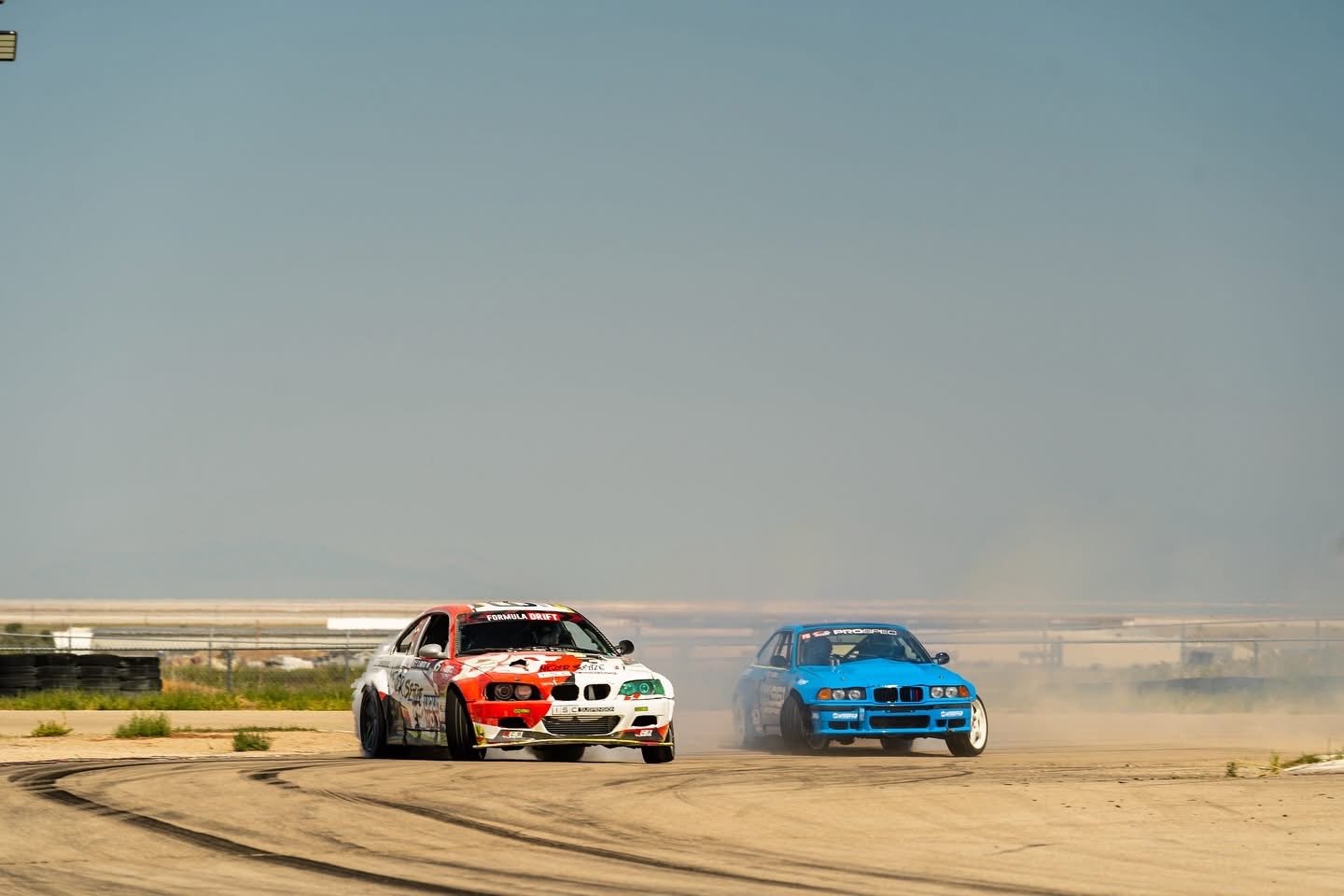 Two drift cars battling in dusty desert track