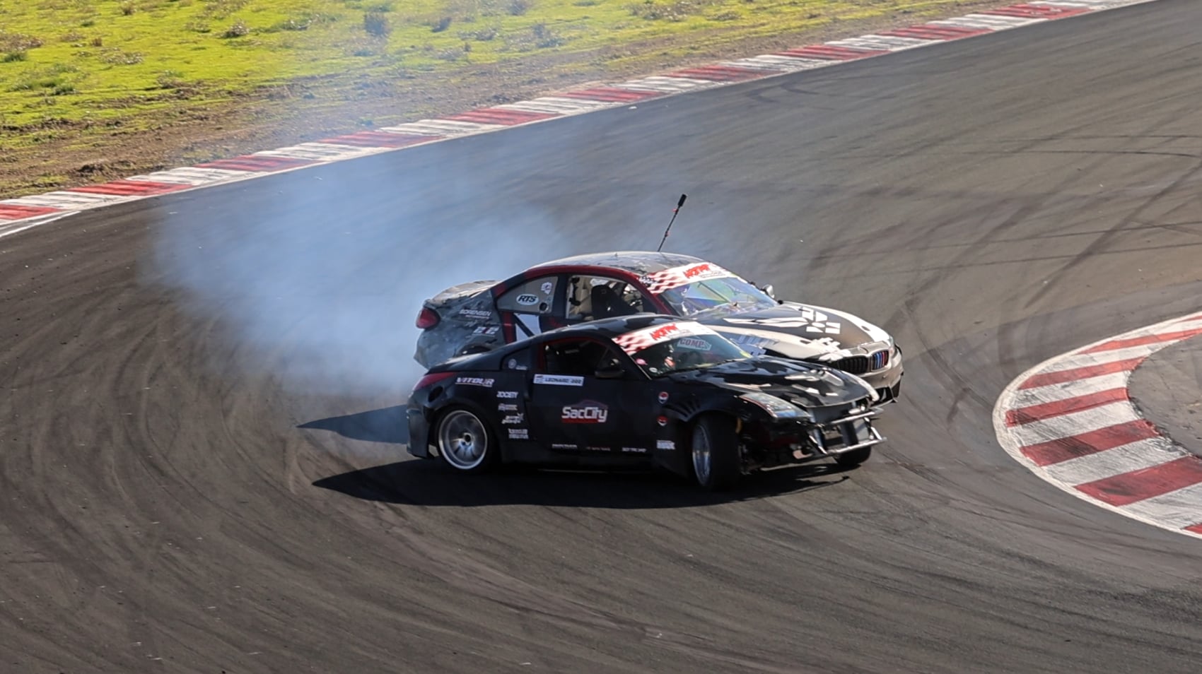 Tandem drifting at Formula Drift hairpin with tire smoke