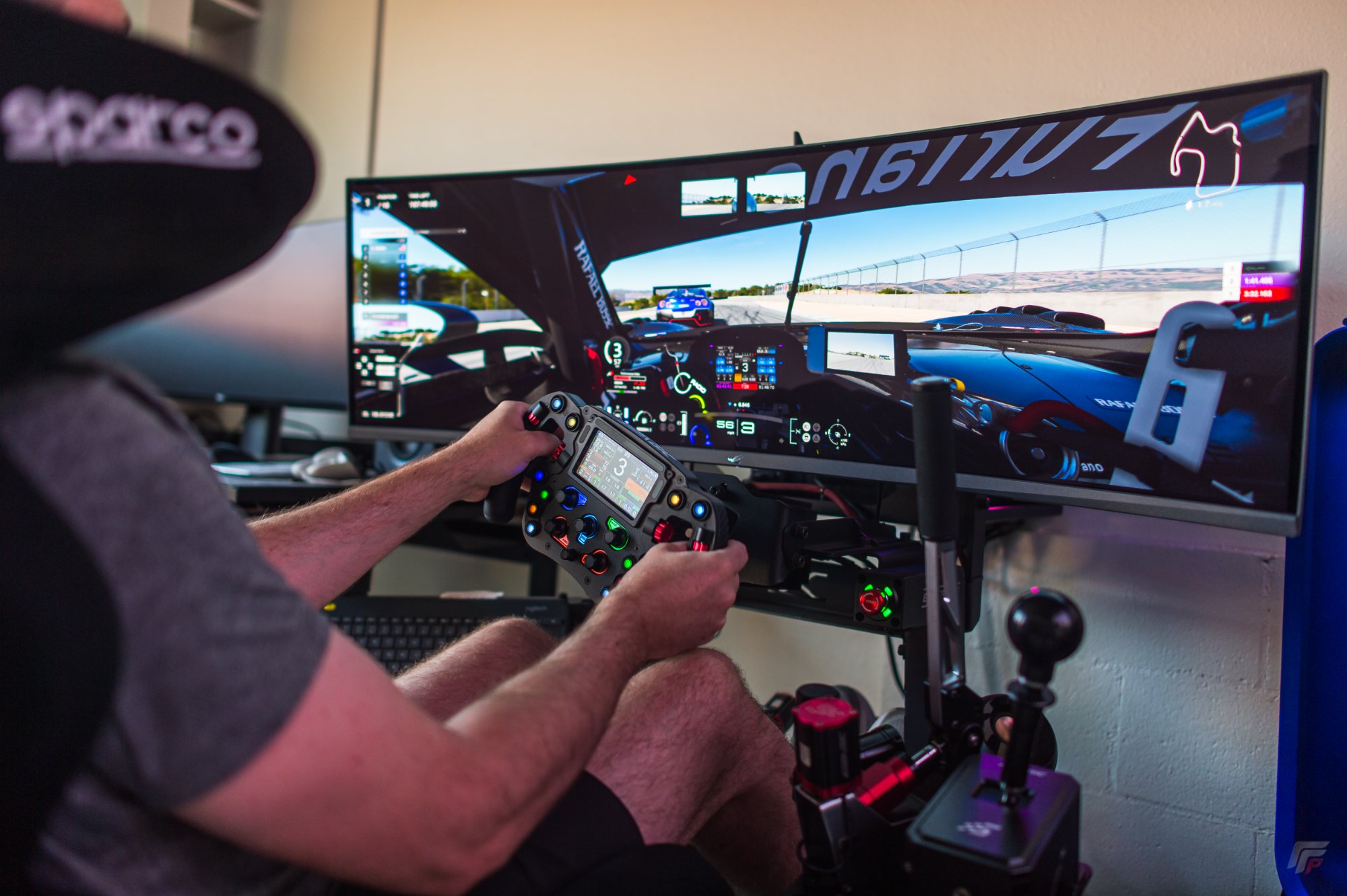 Simagic F1 steering wheel with LCD telemetry display on ultrawide monitor