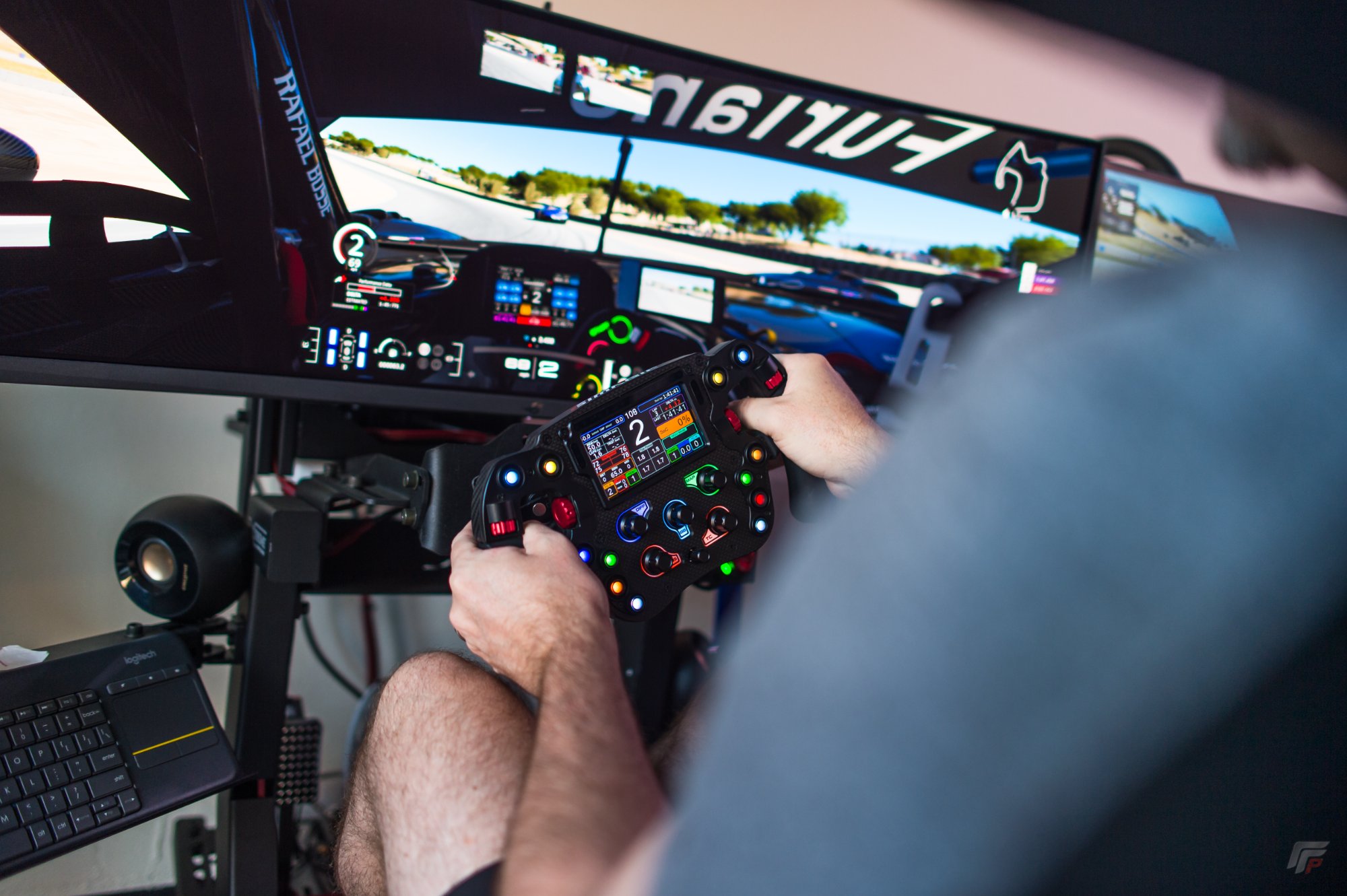 Close-up Simagic F1 wheel with full telemetry display on track